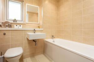 a bathroom with a tub and a sink and a toilet at Old Prestwick View - Donnini Apartments in Prestwick