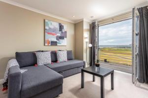 a living room with a couch and a large window at Old Prestwick View - Donnini Apartments in Prestwick