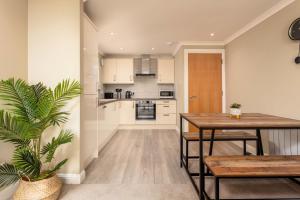 a kitchen and dining room with a table and a plant at Old Prestwick View - Donnini Apartments in Prestwick