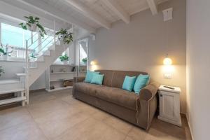 salon z brązową kanapą z niebieskimi poduszkami w obiekcie B&B Il Cortiletto w mieście Porto Cesareo