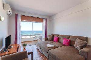 a living room with a couch and a view of the ocean at Vista Mar 4ºc in Armação de Pêra