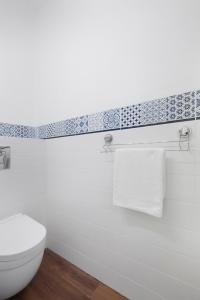 a bathroom with a white toilet and a towel rack at Elite Apartments Sopot Superior in Sopot