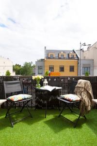 a patio with two chairs and a table on grass at Elite Apartments Sopot Superior in Sopot