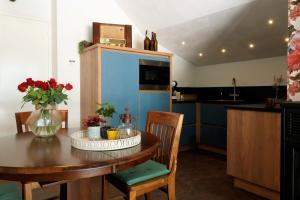 a kitchen with a wooden table and a kitchen with blue cabinets at B&B Bergheide in Baexem