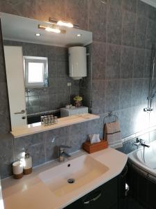 een badkamer met een wastafel en een spiegel bij Holiday House Tina in Pula +30 foto's