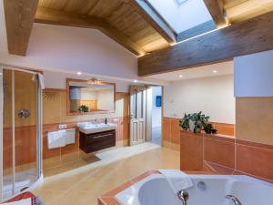 baño con bañera grande y lavamanos en Chalet Weinberg Top 1 & Top 2 by Apartment Managers en Kirchberg in Tirol