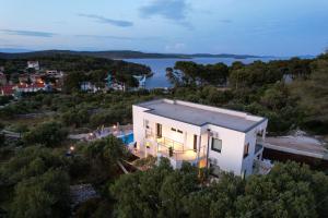 eine Luftansicht auf ein weißes Haus mit einem Pool in der Unterkunft Villa Parisa in Božava