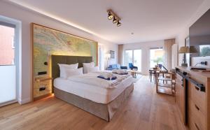 1 dormitorio con 1 cama grande y un mapa grande en la pared en Inselhotel VierJahreszeiten, en Borkum