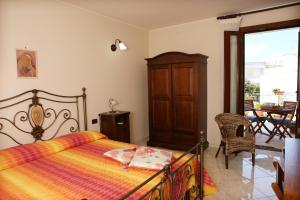 a bedroom with a bed and a chair and a table at B&B Minerva in Castro di Lecce