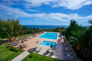 an overhead view of a swimming pool with chairs and the ocean at Zephyros Hotel in Skala