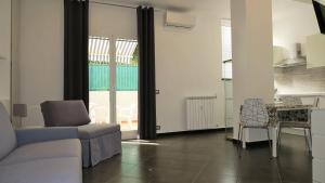 una sala de estar con un sofá y una mesa en Karina, to the beach with terrace and private parking, en Savona 16 fotos más