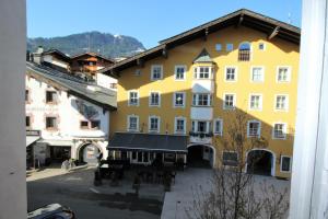 a view of a yellow building in a town at Apartment Glockenspiel by Apartment Managers in Kitzbühel