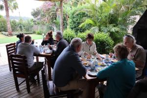 a group of people sitting at a table eating food at 113 on Robberg in Plettenberg Bay