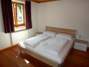 Schlafzimmer mit einem Bett mit weißer Bettwäsche und einem Fenster in der Unterkunft Apartment Kirchberg by Apartment Managers in Kirchberg in Tirol