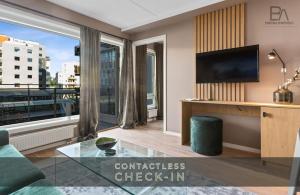 a living room with a tv and a large window at BJØRVIKA APARTMENTS, Teaterplassen, Oslo city center in Oslo