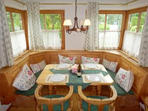 Haus Staudach 1 by Apartment Managers في كتسبويل: غرفة طعام مع طاولة وكراسي ونوافذ