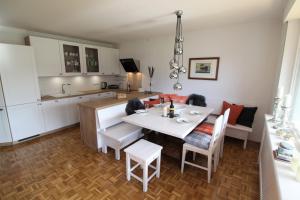 a kitchen and dining room with a white table and chairs at Apartment Weinberg by Apartment Managers in Kirchberg in Tirol
