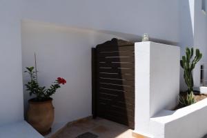 een kamer met twee planten en een bakstenen muur bij Lotos Beach Home in Kinion