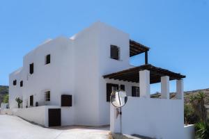 un bâtiment blanc avec un panneau devant lui dans l'établissement Lotos Beach Home, à Kinion