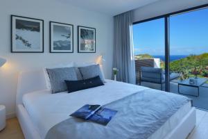 a bedroom with a large bed with a view of the ocean at Rêve de Saint Barth - Vue Mer - Piscine Chauffée & Jacuzzi in Gustavia