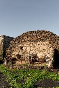 un muro di pietra con due panche e un tavolo di Joya del Jable a Tao