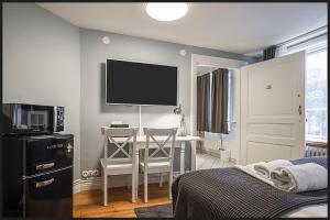Schlafzimmer mit einem Schreibtisch, einem TV und einem Bett in der Unterkunft Continental Apartment Hotel Helsingborg in Helsingborg