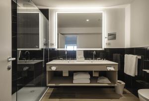 a bathroom with a sink and a toilet and a mirror at Sublimis Boutique Hotel Adults-Only in Camogli