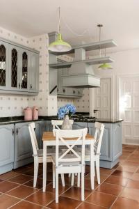 uma cozinha com armários brancos e uma mesa e cadeiras em Cozy Loft Barrika em Górliz