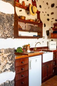 cocina con fregadero y nevera blanca en Joya del Jable, en Tao