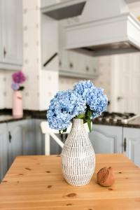 a white vase with blue flowers sitting on a table at Cozy Loft Barrika in Górliz-Elexalde