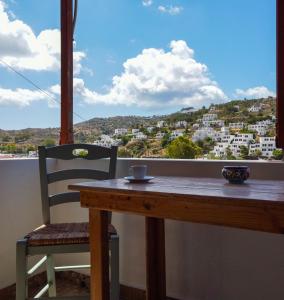 a table and chair with a cup of coffee on a balcony at Mistral-Patmos in Patmos