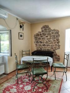 a room with a table and two chairs and a stone fireplace at Villa Sunrise in Herceg-Novi