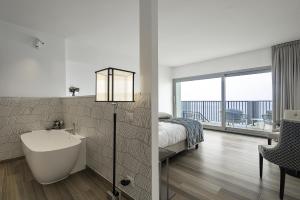 a bathroom with a bed and a bath tub and a bedroom at Sublimis Boutique Hotel Adults-Only in Camogli