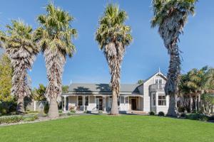 a house with palm trees in front of it at Headlands Estate in Whanganui