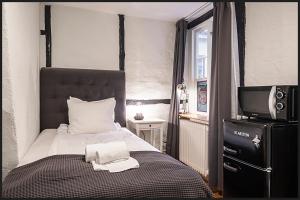 una piccola camera da letto con un letto e una TV di Continental Apartment Hotel Helsingborg a Helsingborg