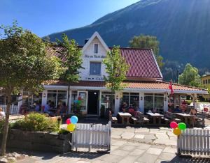 a building with people sitting at tables in front of it at Stryn Kaffebar & Vertshus in Stryn