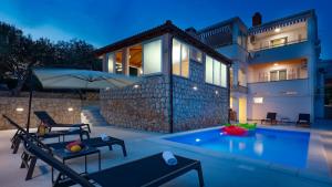 a villa with a swimming pool in front of a house at Apartment Vegas in Novalja