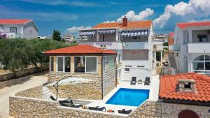 a villa with a swimming pool and a house at Apartment Vegas in Novalja