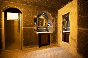 un baño con lavabo y espejo en Antique Terrace Cave Suites, en Göreme 70 fotos más