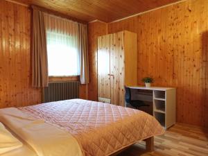 a bedroom with a bed and a desk and a window at Apartmani San in Plitvička Jezera