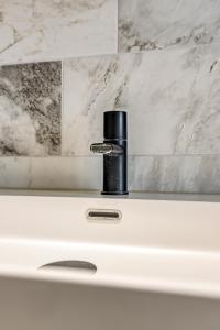 a black object sitting on top of a white sink at Hosted by Wendy Prins Willem 1 in Scheveningen
