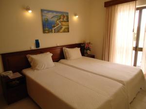 1 dormitorio con 2 camas y un cuadro en la pared en Boutique Hotel Marina S. Roque, en Lagos