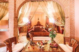 a bedroom with a bed and a table and chairs at Riad Mabrouk in Marrakech