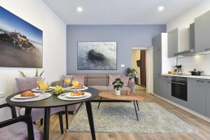 a kitchen and a living room with a table with food at D&A Central Luxury Apartments with FREE Parking in Pula