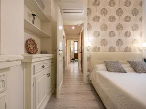 a white bedroom with a bed and a hallway at Marco's stylish home In the heart of Cagliari in Cagliari