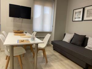 a living room with a table and a couch at Apartamentos Puertas del Orbigo in Carrizo de la Ribera