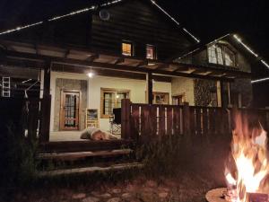a person sleeping on the porch of a house with fires at Загородный клуб Снежные Гуси in Novosnezhnaya
