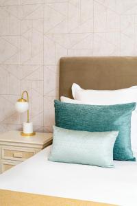 a bed with blue and white pillows and a lamp at Monte Santo Resort in Carvoeiro