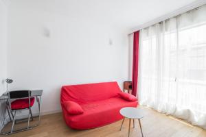 ニースにあるStudio Guiglia - Welkeysの窓付きの客室で、赤いソファが備わります。