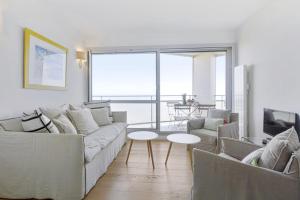 ein Wohnzimmer mit einem Sofa und einem Tisch in der Unterkunft Bright T2 with balcony and sea view in Biarritz in Biarritz